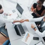 Young employees sitting in the office at the table and using a laptop