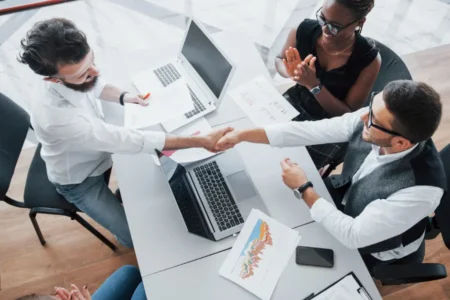 Young employees sitting in the office at the table and using a laptop