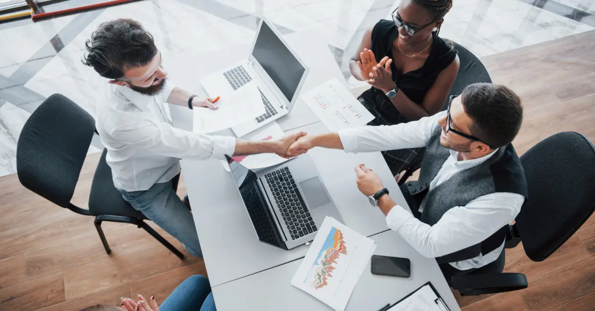 Young employees sitting in the office at the table and using a laptop